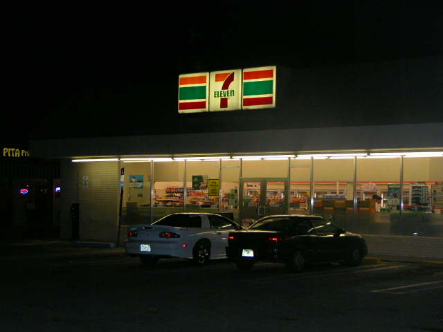 The bar is to the left of 7-eleven